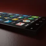 Smartphone lying diagonally on a dark surface displaying colorful app icons on its screen with a soft light highlighting its edge.