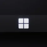 Close-up of a backlit Windows logo on a dark surface, symbolizing the Microsoft Windows operating system.