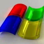 Three-dimensional rendering of semi-transparent red, green, and yellow RGB (Red, Green, Blue) color model capsules overlapping, with a subtle reflection on a gray surface.