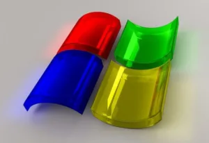 Three-dimensional rendering of semi-transparent red, green, and yellow RGB (Red, Green, Blue) color model capsules overlapping, with a subtle reflection on a gray surface.