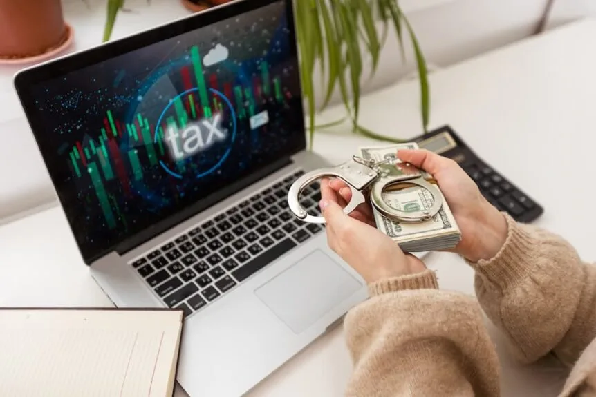 A woman handing a pile of cash to a computer tax scam.